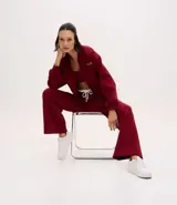Pantalón deportivo de corte recto, confeccionado en tejido de microfibra color bordó. Presenta cintura elástica con cordón ajustable, bolsillos delanteros embutidos y detalle de bordado discreto en la pierna.