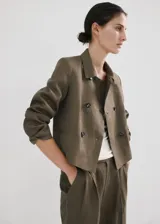 Pantalón de lino verde militar, de diseño recto y tiro alto, con detalle de pinzas y trabillas en la cintura.