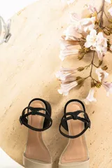 Sandalias de cuero color suela con taco cuadrado bajo y tira ajustable con hebilla en el tobillo.