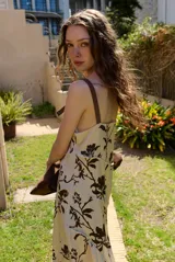 Vestido largo sin mangas de corte evasé con estampado abstracto en tonos bordó, beige y rosado, escote en V y tirantes finos.