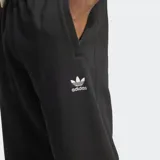 Pantalón de jogging negro Adidas de corte ceñido, confeccionado en felpa francesa. Cuenta con cintura elástica con cordón ajustable, bolsillos laterales, puños acanalados y logo del Trifolio en la pierna.