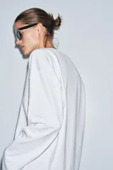 Camiseta blanca de algodón con escote en pico, manga larga y bajo recto.