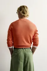 Jersey relaxed fit de punto tejido en hilatura de algodón con cuello redondo, manga larga y efecto lavado. Presenta un pequeño bordado en el delantero y acabados en rib. Colección especial Fruit of the Loom x Zara.