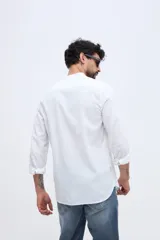 Camisa de lino y algodón color celeste, con cuello mao, cierre frontal de botones claros y pequeño bordado de pato en el pecho.