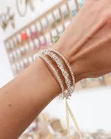 Pulsera de diseño multicapa compuesta por tres hilos de strass plateado, con un estilo brillante y elegante.