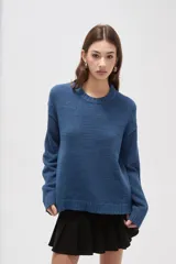 Sweater de tejido de punto color azul, con cuello redondo, manga larga y diseño holgado.