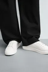 Zapatillas urbanas de cuero sintético negro, con cordones y suela gruesa monocolor.