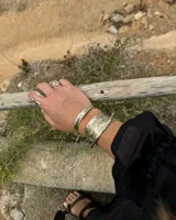 Brazalete rígido de diseño artesanal con textura irregular y acabado metálico, elaborado en bronce macizo.