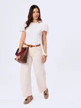 Jean de corte barrel color beige, de tiro medio y diseño amplio en las piernas con costuras pespunteadas a contratono.