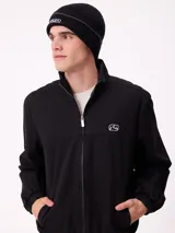 Gorro tipo beanie de punto acanalado color azul marino, con detalle de franja blanca y logo de la marca bordado en el frente.