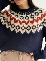 Sweater de cuello redondo con diseño de jacquard estilo nórdico en la parte superior, combinando tonos azul marino, blanco y rojo. Presenta mangas largas y puños acanalados.