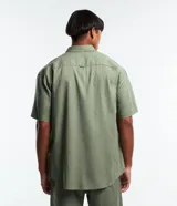 Camisa de corte relajado para hombre, confeccionada en una mezcla de cáñamo y algodón. Presenta cuello inglés, manga corta, cierre frontal con botones y un bolsillo en el pecho con una pequeña etiqueta aplicada.