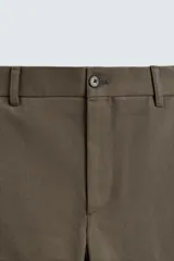 Pantalón de corte recto confeccionado en tejido compacto de algodón con estructura twill. Presenta cierre frontal con cremallera y botón, bolsillos laterales y bolsillos traseros de vivo con botón.