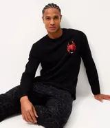 Pijama largo de hombre confeccionado en algodón, compuesto por una remera negra de manga larga con cuello redondo y estampa localizada de Spider-Man en el pecho, y un pantalón con estampado integral de telarañas y cintura elástica.