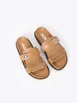 Sandalias planas color tostado de cuero vacuno, con capellada adornada con flecos y una tira con hebilla metálica.