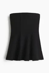 Top strapless largo en punto tupido color negro, con costuras enlazadas y peplum acampanado.