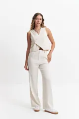 Chaleco corto color marrón topo, con escote en V asimétrico y cierre cruzado con botones.