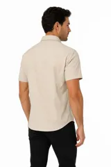 Camisa negra de manga corta, con cuello clásico, cierre frontal con botones y bolsillo ojal en el pecho.