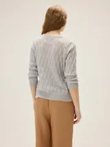 Buzo de punto en lurex color gris con escote en V y silueta relajada.