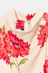 Vestido midi de color beige con estampado floral en tonos rojos y fucsias, con cuello fluido, manga sisa y cinturón del mismo tejido.