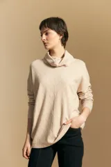Polera de tejido de punto color naranja con cuello alto de caída relajada y diseño de líneas en relieve. Presenta una silueta holgada con hombros caídos y mangas largas.