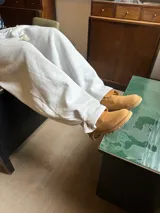 Pantalón de jogging gris melange de corte baggy, confeccionado en algodón. Presenta cintura elástica con cordón largo ajustable, bordado decorativo en la pierna izquierda y botones metálicos en la parte inferior de la botamanga para ajustar el ancho.