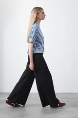 Remera de manga corta con cuello a la base, confeccionada en tejido de rayas horizontales blancas y negras, con silueta relajada.