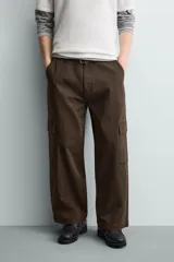 Pantalón cargo de corte relajado confeccionado en tejido de algodón con elasticidad. Presenta bolsillos laterales tipo cargo con solapa en las perneras, bolsillos frontales y bolsillos traseros de doble vivo. Cierre frontal con cremallera y botón.
