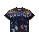 Remera negra de algodón con estampado gráfico frontal que presenta una pantera rugiendo, soles caricaturizados y el texto Valley Dreams. Posee un efecto de lavado desgastado y detalles de roturas en los bordes de las mangas y el ruedo.