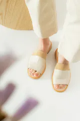 Sandalias planas de cuero marrón con tira ancha sobre el empeine. La plantilla es de cuero con la inscripción "LE".