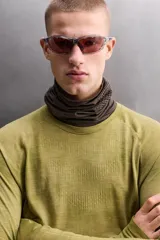 Camiseta térmica de manga larga ranglán, cuello redondo, color verde oliva con efecto tie-dye o jaspeado. Presenta tejido con lana, alta elasticidad y ajuste al cuerpo, con estructuras combinadas para facilitar la transpiración y sin costuras.