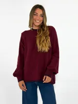 Sweater de tejido de punto en color bordó, con cuello redondo, mangas largas con puños ajustados y diseño holgado.