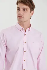 Camisa de vestir blanca de manga larga, con cuello abotonado, bolsillo frontal y botones en tono madera.