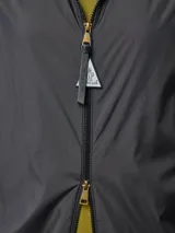 Campera rompevientos Moncler modelo Enette, color negro, con capucha, cierre frontal y puños elásticos. Presenta el logo de la marca aplicado en la manga izquierda.
