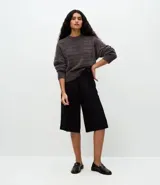 Suéter de punto chenille color gris oscuro, con cuello redondo alto, textura acanalada y puños ajustados.