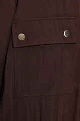 Chaqueta corta marrón de cuello solapa y manga remangada por debajo del codo. Presenta bolsillos delanteros de plastrón con solapa, bajo ajustable con cordón interior y cierre frontal con botones.