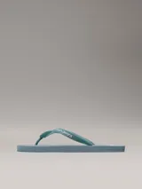 Chancletas Calvin Klein color celeste con logo de la marca en la tira.