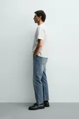 Jeans regular fit de denim de algodón en color gris con efecto lavado, tiro medio, diseño de cinco bolsillos y cierre frontal con botones.