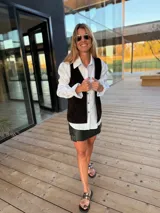 Chaleco de cuero marrón con detalle de tachas en el contorno.