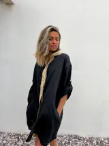 Camisa negra de lino con cuello clásico, cierre frontal con botones color beige y mangas 3/4 con trabillas.