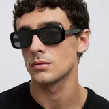 Lentes de sol con montura rectangular de perfil ancho y diseño minimalista. Cuentan con lentes polarizadas de color negro y montura de material bio-based.