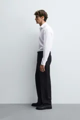 Camisa de corte regular fit confeccionada en tejido de algodón con textura. Presenta cuello clásico, manga larga con puños abotonados y cierre frontal con botones.