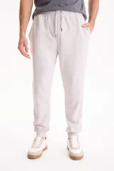 Pantalón de jogging negro sin friza, con puños elastizados en los tobillos y cordón ajustable en la cintura.