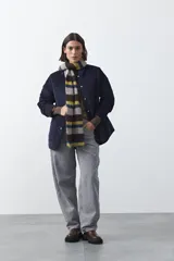 Campera capitoneada de algodón con diseño matelaseado, cuello camisero y cierre frontal con botones a presión. Presenta un corte relajado y bolsillos frontales.