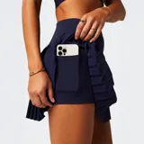 Minifalda plisada de tiro alto con shorts incorporados, confeccionada en tejido técnico transpirable. Presenta un diseño deportivo con cintura elástica ancha y bolsillos ocultos.