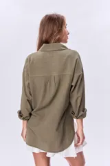 Camisa verde militar de manga larga con dos bolsillos frontales con solapa y cierre con botones.