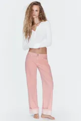 Jeans de tiro bajo con corte holgado, cinco bolsillos y bajo con vuelta. Cierre frontal con cremallera y botón metálico.