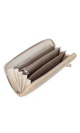 Billetera de dama en símil cuero color negro, de diseño acolchado con costuras verticales que forman relieves y cierre perimetral. Incluye monograma en la esquina inferior y viene con caja de presentación estampada.