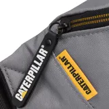 Riñonera Caterpillar (CAT) color gris medio, con compartimento principal con cierre de cremallera y tirador de tela con el logo de Caterpillar. Presenta un parche con el logo CAT en el frente y cierre con cremallera amarilla.