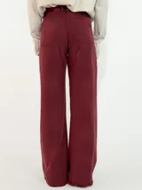 Pantalon de corte recto y tiro medio, confeccionado en gabardina color marrón. Presenta cierre frontal con botón y bolsillos laterales.